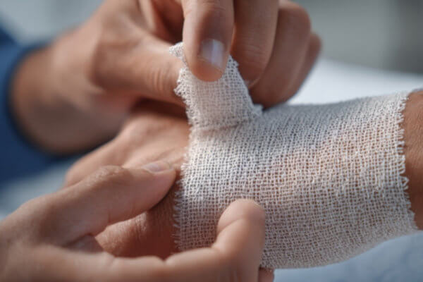 doctor applying bandage on patients hand