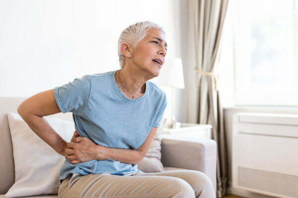 an older woman having back pain due to osteoporosis
